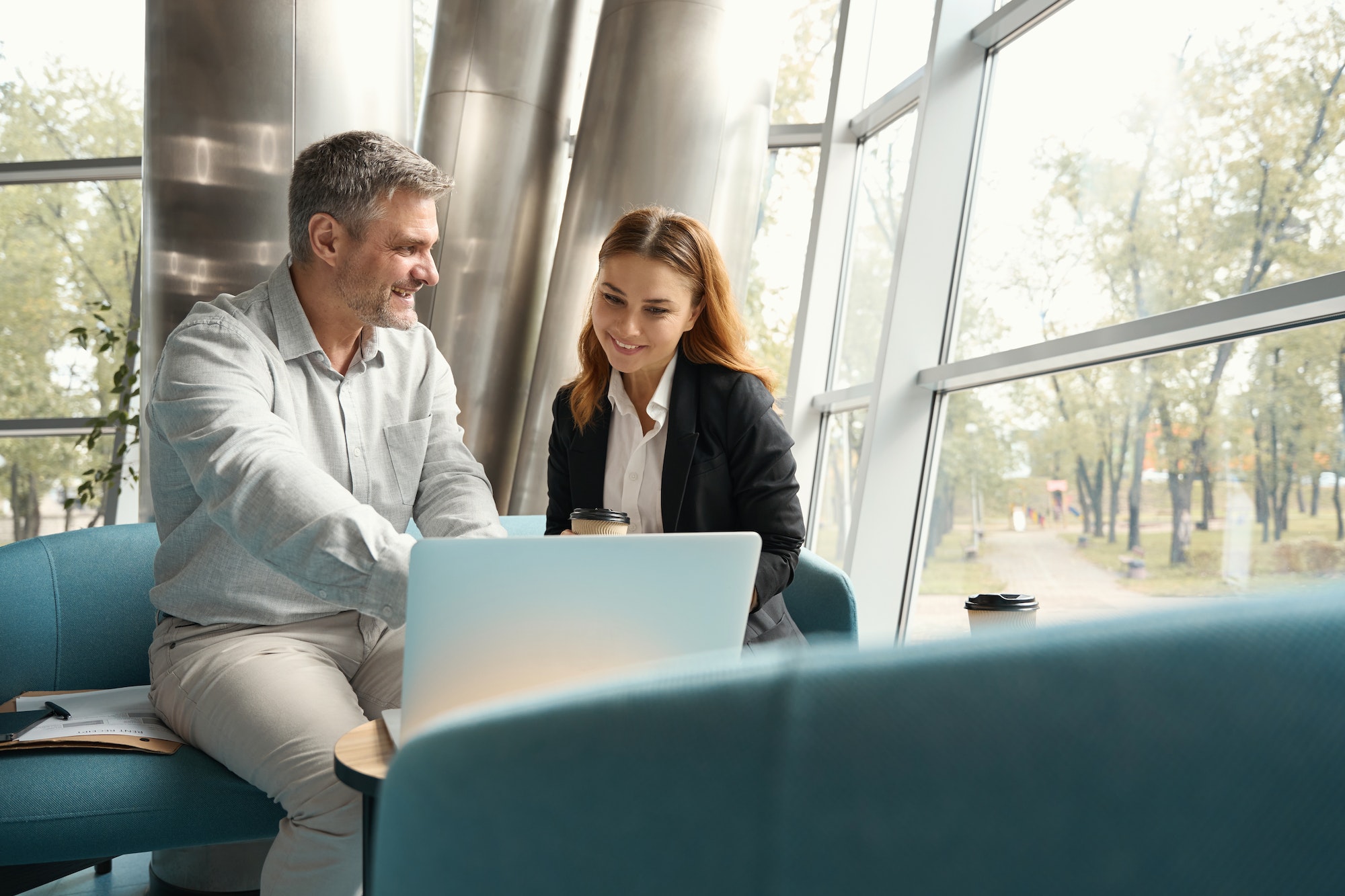 Employees communicate in the office recreation area on blue sofa
